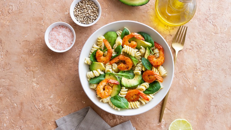 Pasta salad with shrimp, avocado and spinach.