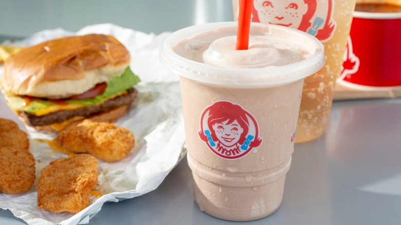 A Wendy's frosty next to some chicken nuggets and a burger