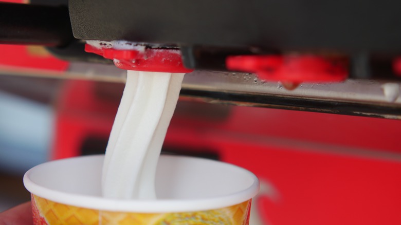 ice cream machine dispensing vanilla soft serve into a cup