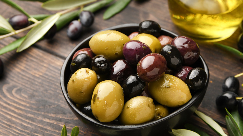 Olives in a small black bowl with olive oil