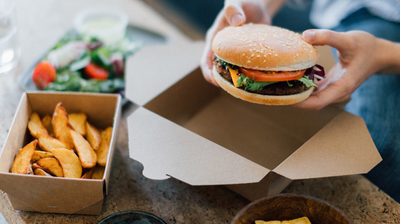 Hamburger and fries in cardboard delivery boxes