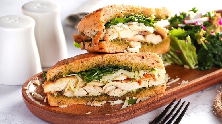 Halved chicken, pesto, and spinach sandwich