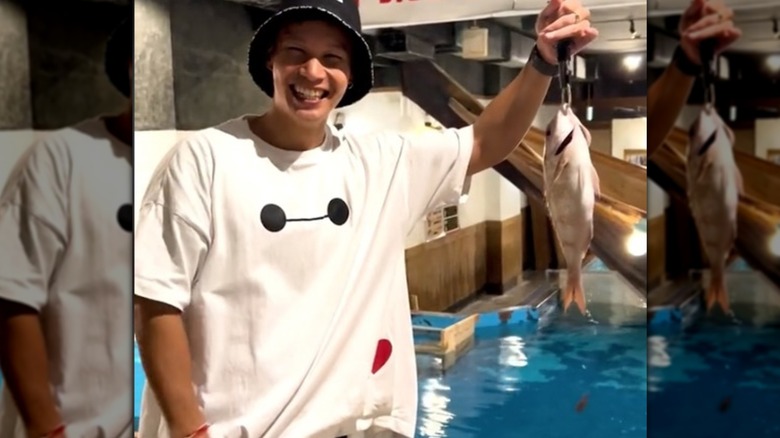 Man holding fish he caught at Zauo