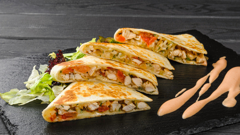 Fajita chicken quesadilla on black stone cutting board