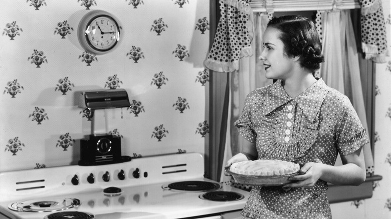 black and white photo of a 1930s home cook with a pie