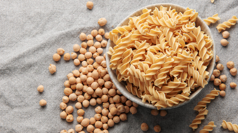 Bowl of chickpea pasta surrounded by chickpeas