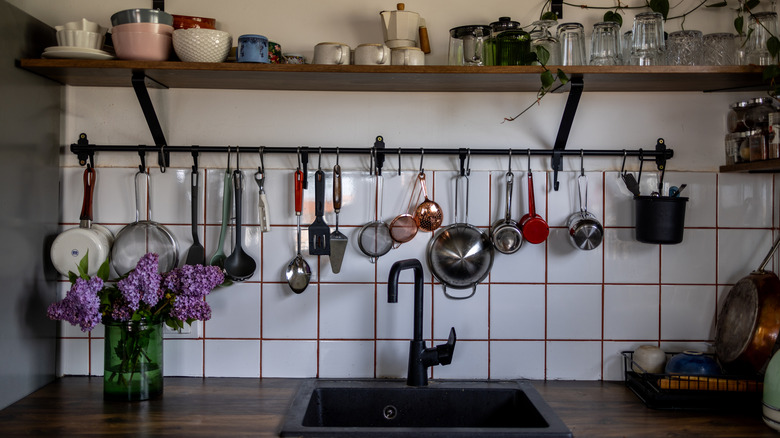 Utility hooks with tools hanging under a kitchen shelf