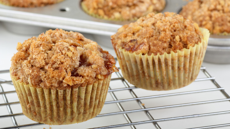 Two coffee cake muffins on a wire rack
