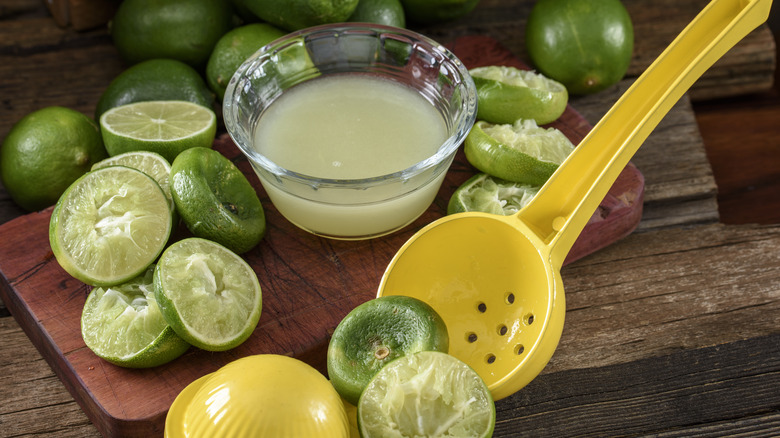 Handheld citrus juicer with limes.