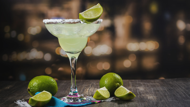 Margarita in salt-rimmed glass with limes