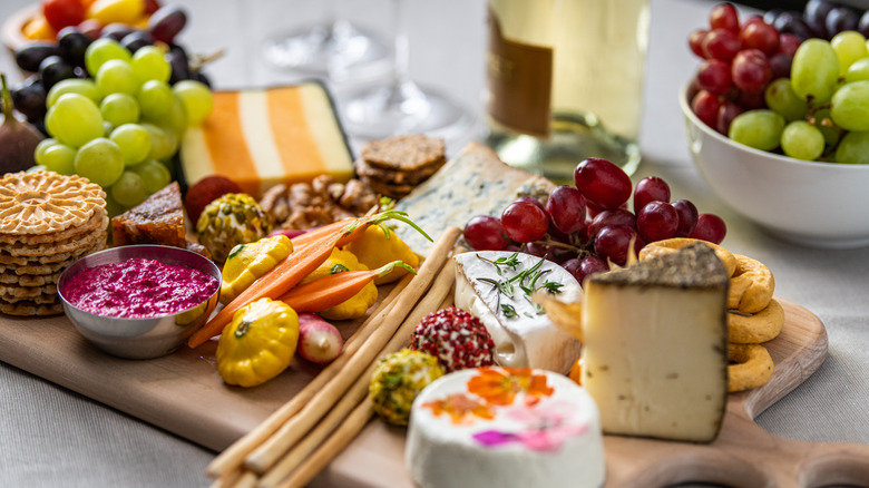 Cheese board with vegetables, fruit, and dips