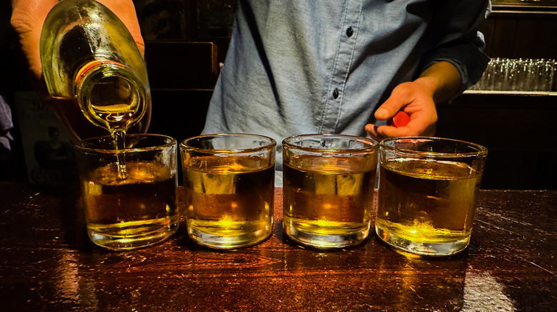 speakeasy whiskey being poured into glasses