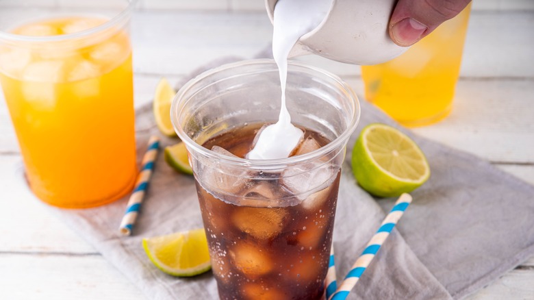 Pouring creamer into soda cup