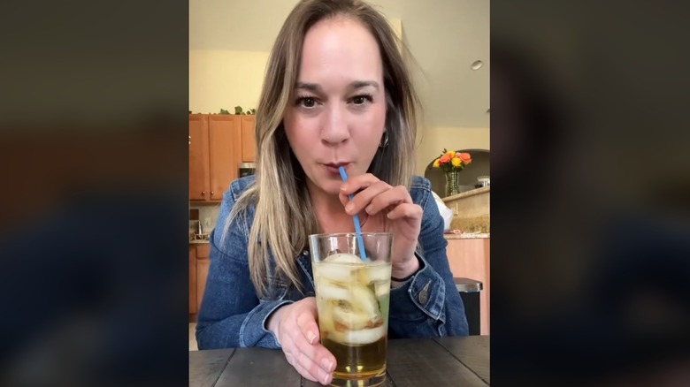 A woman drinking a mixed drink