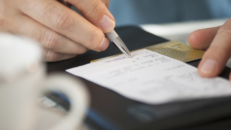 Person signing a check at a restaurant