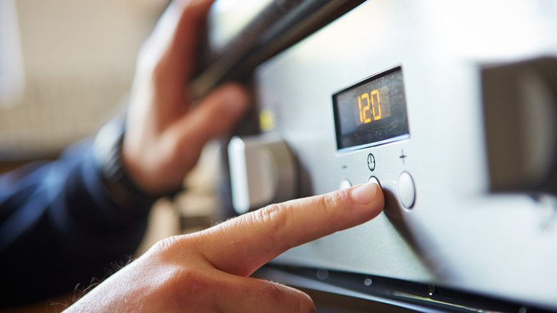 Man turning dial on oven