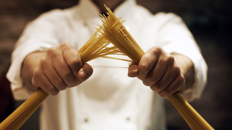 Chef holds spaghetti noodles