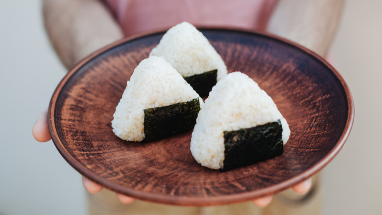 Partially wrapped onigiri on a plate