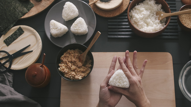 Hands forming onigiri rice triangles