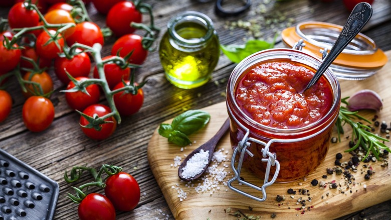 Tomato sauce in jar next to ingredients