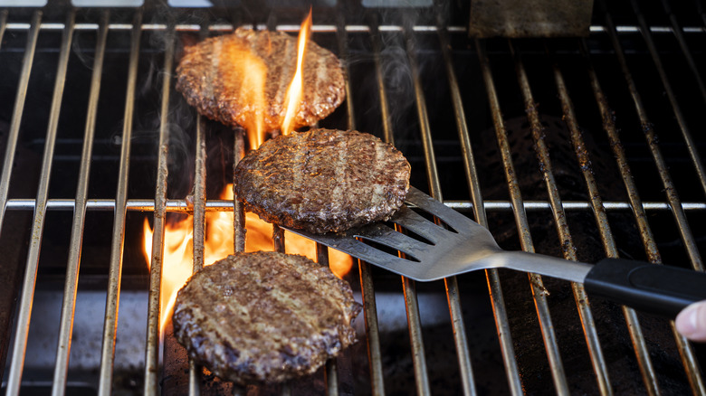 Burgers cooking on a fiery grill