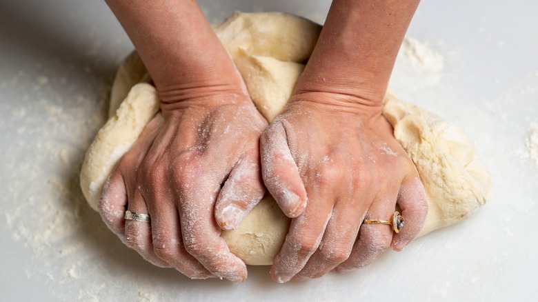 Hands kneading pie dough