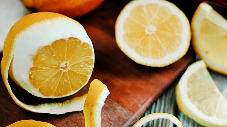 Lemon with spiral peels on wood