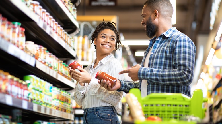 couple shopping in supermarket aisle