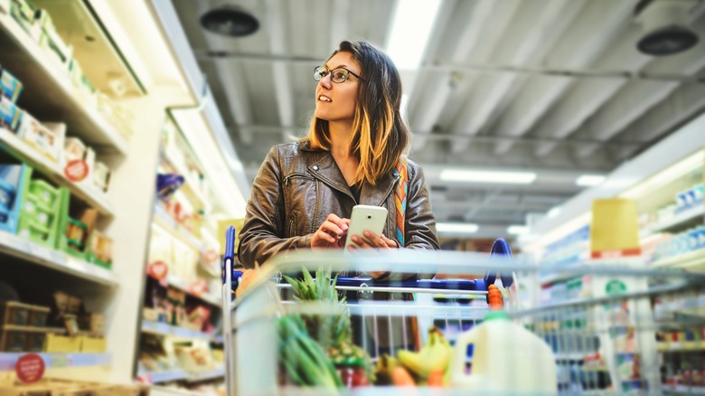 woman shopping supermarket refrigerated section