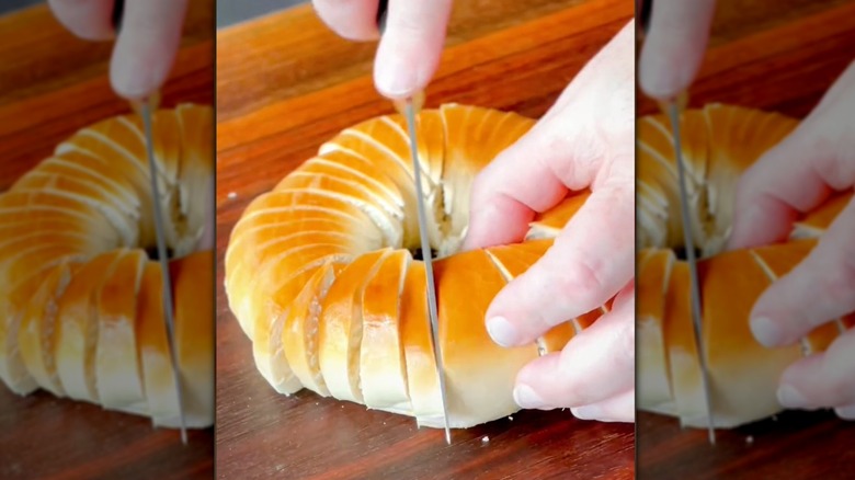 person cutting bagel into slices