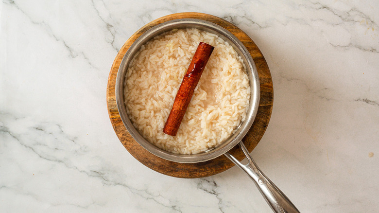 Pot with cooked rice and cinnamon stick