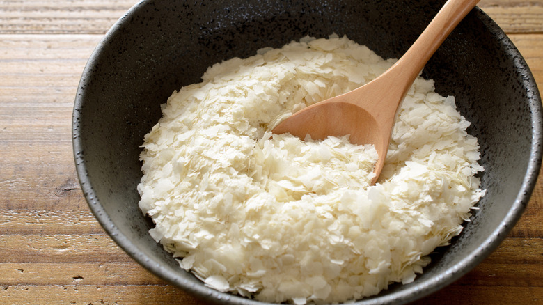 A spoon rests in a bowl of instant mashed potato flakes.