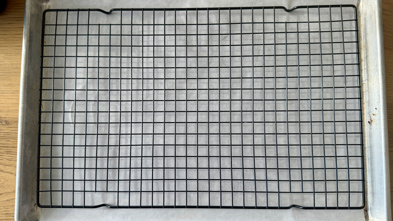 Parchment-lined baking sheet with wire rack on top