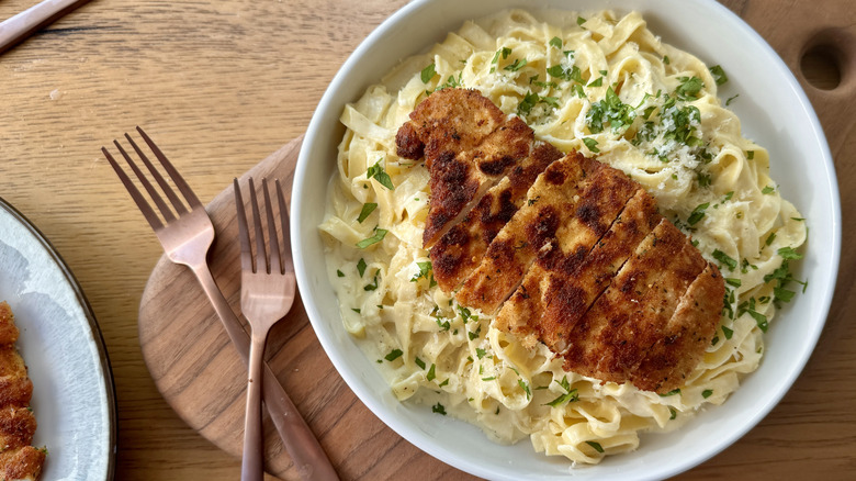 Fettuccine Alfredo with sliced chicken on plate