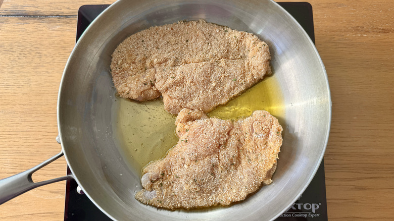 Breaded chicken cooking in skillet