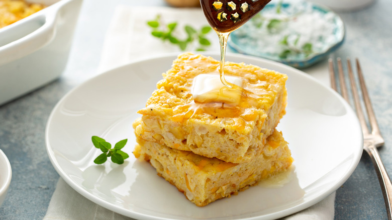 Squares of cheesy cornbread with honey