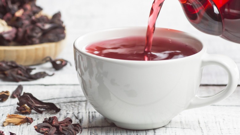 Pouring hibiscus concentrate into a tea mug