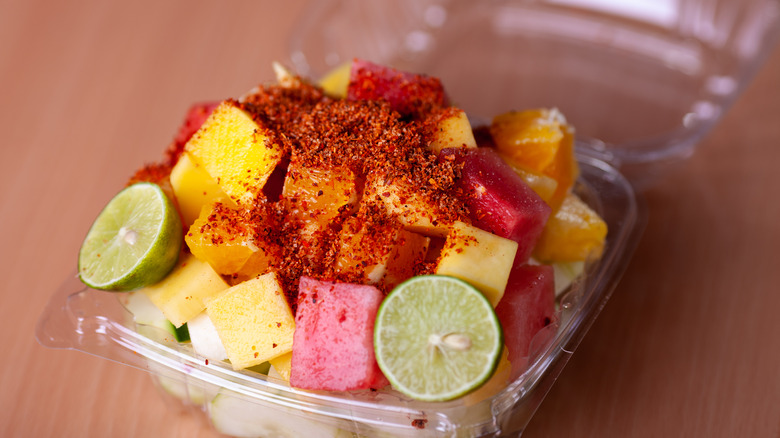 A container of fruit covered in tajin