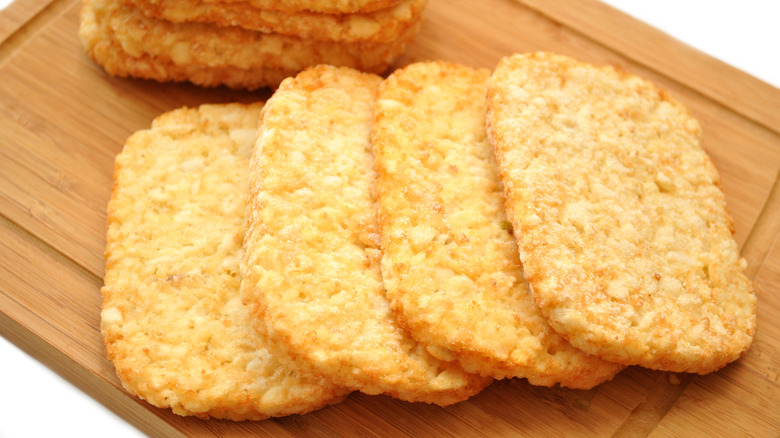 Frozen hash brown patties on a wooden cutting board