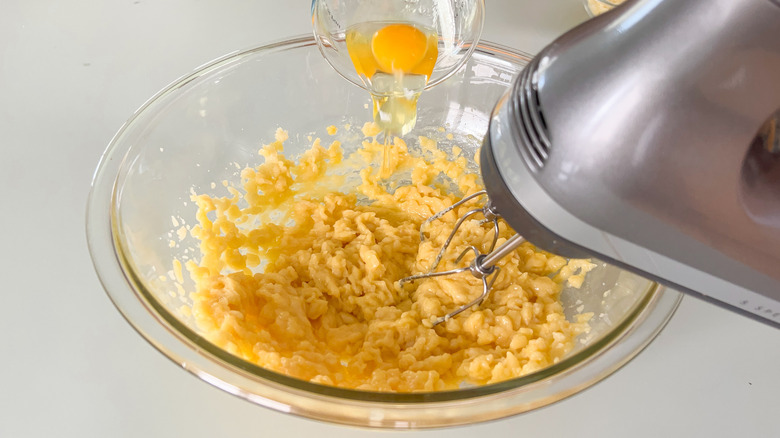 Using hand mixer to add eggs to gougerè dough in mixing bowl