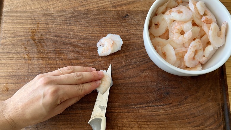 slicing shrimp on cutting board