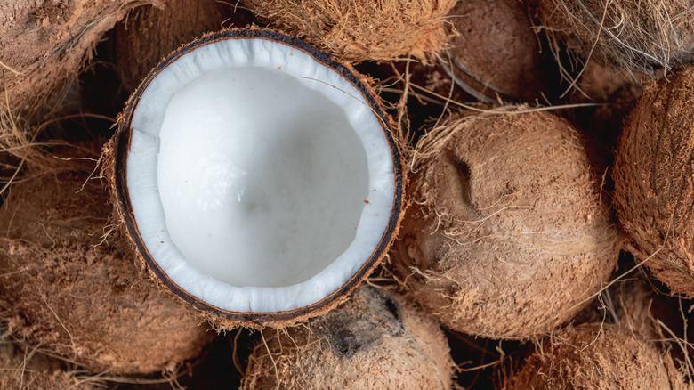 Pile of coconuts with one cut in half on top