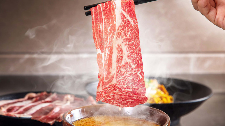 A piece of wagyu beef being cooked shabu shabu style.