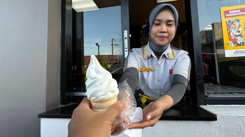 Person handing over a McDonald's ice cream cone