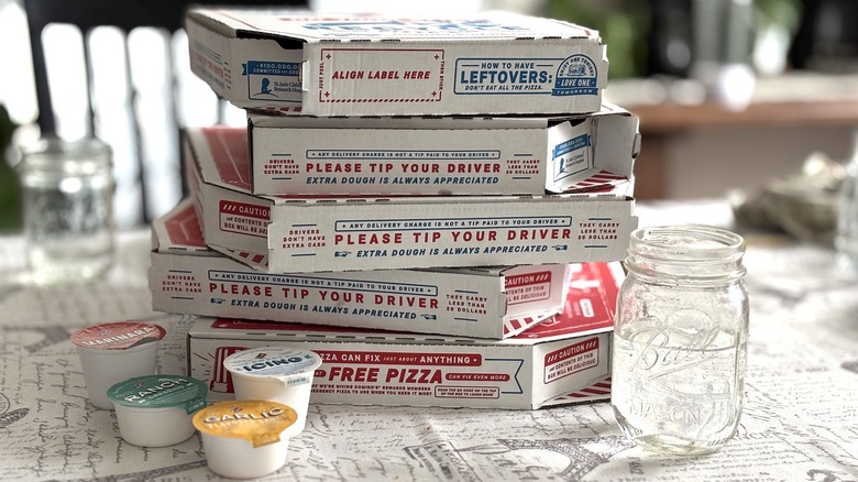 stack of five Domino's pizza boxes and dipping sauces