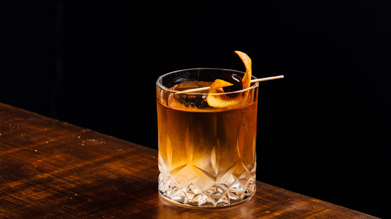 Old-fashioned cocktail with bitters and orange peel