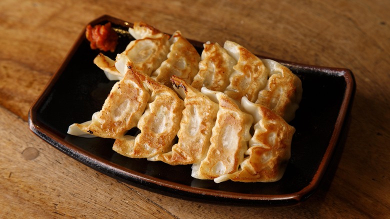 Black rectangular platter with 10 fried gyoza