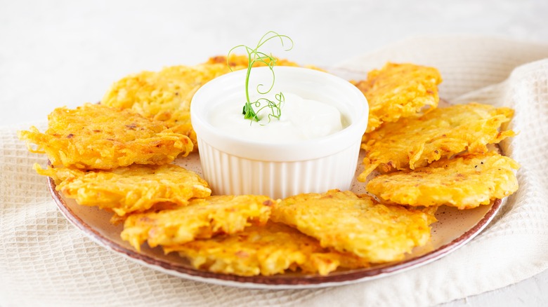 latkes surrounding sour cream bowl