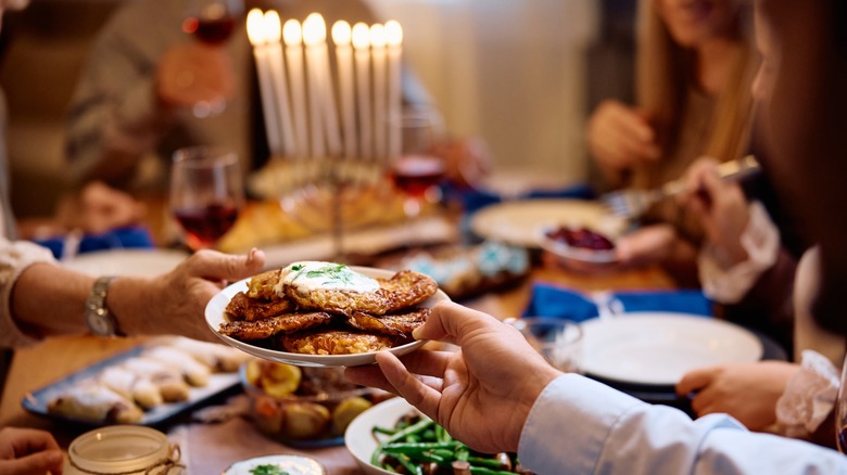 hand passing plate of latkes