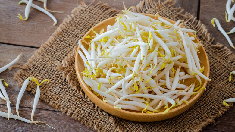 Bean sprouts in a wooden bowl on a burlap placemat